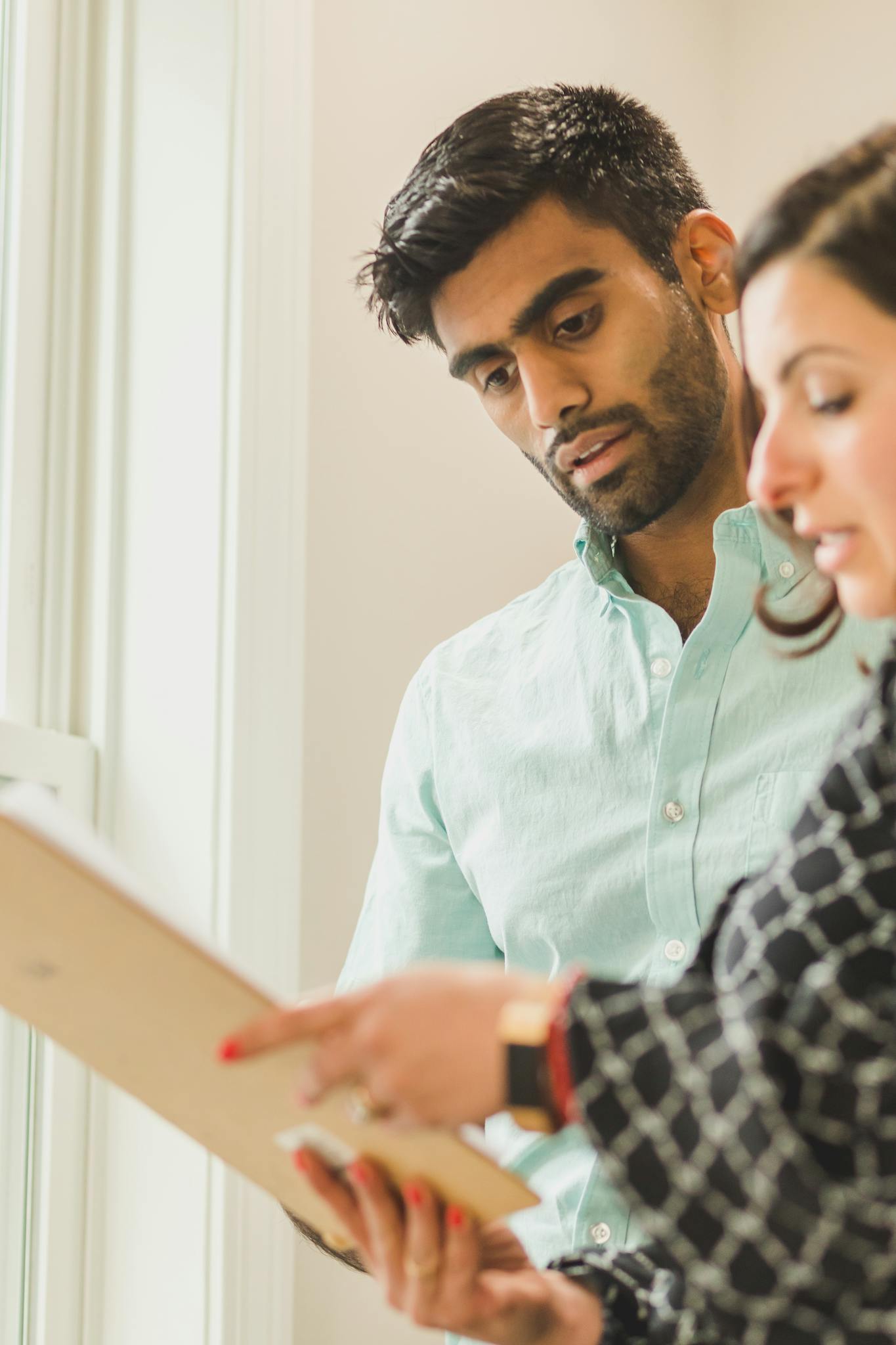 A real estate agent consulting with a couple on buying their first home.